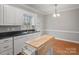 Bright view of the kitchen and dining area with white cabinets, black counters, and hardwood floors at 405 N Wilson St # 103, Rock Hill, SC 29730