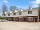 A multi-unit townhome complex featuring brick facades, white siding, and ample parking space at 405 N Wilson St # 103, Rock Hill, SC 29730