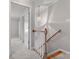 Hallway with gray walls, carpet, and wood railing with a pendant light on the stairwell at 405 N Wilson St # 103, Rock Hill, SC 29730