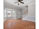 Well-lit living space featuring hardwood floors, a staircase, and a bay window for natural light at 405 N Wilson St # 103, Rock Hill, SC 29730