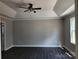 Spacious bedroom with tray ceilings, a ceiling fan, hardwood floors, and a large window, offering a comfortable retreat at 4168 S Olivers Cross Rd # 6, Newton, NC 28658