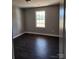 A bright bedroom with dark hardwood floors and a window to the outside at 4168 S Olivers Cross Rd # 6, Newton, NC 28658