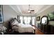 Spacious main bedroom features a tray ceiling, ceiling fan, a large window, and dark wood furniture at 447 Shagbark Ct, Mount Gilead, NC 27306