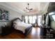 Bright main bedroom with tray ceiling, ceiling fan, dark wood furniture, and an exterior door to the outside at 447 Shagbark Ct, Mount Gilead, NC 27306