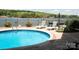 Relaxing pool area with lake views, lounge chairs, and privacy fence at 447 Shagbark Ct, Mount Gilead, NC 27306