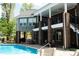Backyard pool area featuring a multi-story home with a covered patio and outdoor seating at 447 Shagbark Ct, Mount Gilead, NC 27306