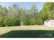 Picture of a spacious backyard with mature trees, lush lawn, storage shed, and playhouse at 4707 Hannah Dr, Rock Hill, SC 29732
