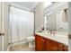 Bathroom with a shower with a curtain, wooden vanity, decorative flowers, sink, and a large mirror at 5103 Trinity Trace Ln, Monroe, NC 28110