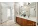 Bright bathroom featuring a double sink vanity, tiled floor, white cabinets, and modern fixtures at 5103 Trinity Trace Ln, Monroe, NC 28110