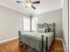 Cozy bedroom with hardwood floors, black iron bed frame, crown molding, and a ceiling fan for added comfort at 5103 Trinity Trace Ln, Monroe, NC 28110
