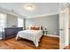 Inviting bedroom with hardwood floors, neutral paint, windows, and a dresser at 5103 Trinity Trace Ln, Monroe, NC 28110