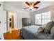 Bedroom with hardwood floors, ceiling fan, grey furniture, and natural light from a window at 5103 Trinity Trace Ln, Monroe, NC 28110