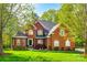Traditional two-story brick home with manicured lawn and lush landscaping, offering timeless curb appeal at 5103 Trinity Trace Ln, Monroe, NC 28110