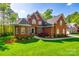 Attractive brick home featuring a manicured lawn and mature landscaping, creating a welcoming curb appeal in a desirable neighborhood at 5103 Trinity Trace Ln, Monroe, NC 28110
