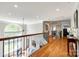 Spacious hallway with hardwood flooring, iron railing, lots of natural light, and a view of the living area below at 5103 Trinity Trace Ln, Monroe, NC 28110