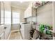 Functional laundry room with washer, dryer, storage shelves, and natural light from the window at 5103 Trinity Trace Ln, Monroe, NC 28110