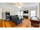 Spacious living room featuring hardwood floors, a comfortable sofa, and an entertainment area at 5103 Trinity Trace Ln, Monroe, NC 28110