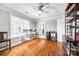 Office with hardwood floors, shelving, adjustable standing desk, bright natural light, and neutral wall color at 5103 Trinity Trace Ln, Monroe, NC 28110