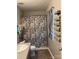 Bathroom featuring a shower with patterned curtain, window with blinds, and a decorative towel rack at 529 Tribune Dr, Charlotte, NC 28214