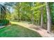 Backyard featuring a lush lawn, mature trees, and a glimpse of the home's screened porch at 62 Pond View Ln, Fort Mill, SC 29715