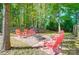 Outdoor firepit with stone pavers and seating in wooded backyard at 62 Pond View Ln, Fort Mill, SC 29715
