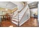 Bright foyer featuring hardwood floors, a staircase with white spindles, and an adjacent formal dining room at 62 Pond View Ln, Fort Mill, SC 29715