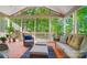 Relaxing screened porch featuring tile floors, comfortable seating, and picturesque views of the surrounding nature at 62 Pond View Ln, Fort Mill, SC 29715