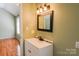 Bright bathroom featuring a modern vanity and hardwood floors in an adjacent room, creating a fresh and clean space at 6779 Highway 557 Hwy, Clover, SC 29710