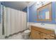 Bathroom featuring blue walls, a shower with a white curtain, and a light wood vanity at 6809 Copernicus Cir, Charlotte, NC 28226