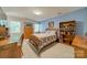 Bedroom with blue accent wall, wood furniture, bed with a patchwork quilt, and a built-in bookshelf at 6809 Copernicus Cir, Charlotte, NC 28226