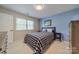 Bedroom featuring blue walls, a bed with a checkered quilt, and a window with natural light at 6809 Copernicus Cir, Charlotte, NC 28226