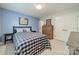 Cozy bedroom with a blue accent wall, comfortable bed, and ample storage space with a dresser and closet at 6809 Copernicus Cir, Charlotte, NC 28226