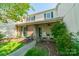 Charming townhome featuring a front porch with white chairs, lush landscaping, and traditional green shutters at 6809 Copernicus Cir, Charlotte, NC 28226
