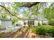 A relaxing deck area with outdoor furniture surrounded by mature trees in a private backyard at 6815 Old Post Rd, Charlotte, NC 28212