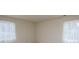 A bedroom bathed in natural light through two windows dressed with sheer curtains at 6815 Old Post Rd, Charlotte, NC 28212