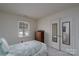 Inviting bedroom with twin bed, dresser, built in dresser, and mirrored closet doors at 6815 Old Post Rd, Charlotte, NC 28212
