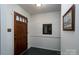 A clean entryway with a dark wood front door and dark tile floor near a hallway at 6815 Old Post Rd, Charlotte, NC 28212