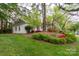 A charming white brick home featuring a well maintained lawn and flowering azaleas lining the front at 6815 Old Post Rd, Charlotte, NC 28212