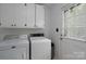 Clean laundry room with white cabinetry, appliances, and convenient outdoor access at 6815 Old Post Rd, Charlotte, NC 28212