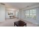 Bright living room with large window and neutral carpet with view to dining area at 6815 Old Post Rd, Charlotte, NC 28212