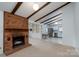 Open floor plan featuring a brick fireplace, wood beam ceiling, and updated kitchen at 6815 Old Post Rd, Charlotte, NC 28212