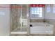 Inviting bathroom with a glass shower and an elegant soaking tub with tiled walls at 7023 Butternut Oak Ter, Huntersville, NC 28078