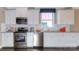 Modern kitchen featuring stainless steel appliances, white cabinets, granite counters, and hardwood floors at 7023 Butternut Oak Ter, Huntersville, NC 28078