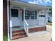 Inviting front porch featuring white railings, brick accents, decorative wreath, and exterior lighting at 715 Cody Ct, Fort Mill, SC 29715
