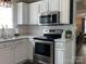 Well-lit kitchen features stainless steel appliances, white cabinetry, and tile backsplash at 715 Cody Ct, Fort Mill, SC 29715