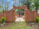 Charming brick-walled garden entrance featuring a central fountain and manicured landscaping at 740 Woodlawn Ave, Mount Holly, NC 28120