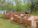 Aerial view of a brick-walled garden featuring a central fountain and manicured landscaping at 740 Woodlawn Ave, Mount Holly, NC 28120