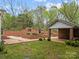 Landscaped backyard with brick-walled garden, fountain, and detached garage at 740 Woodlawn Ave, Mount Holly, NC 28120