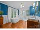 Stylish bathroom featuring a standalone tub, white tiled shower, dual sink vanity, and hardwood floors at 740 Woodlawn Ave, Mount Holly, NC 28120