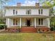 Charming two-story home featuring a welcoming front porch with classic columns and well-maintained landscaping at 740 Woodlawn Ave, Mount Holly, NC 28120